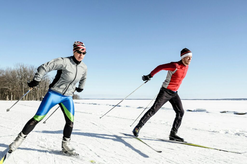 Male and female athletes cross-country skiing.