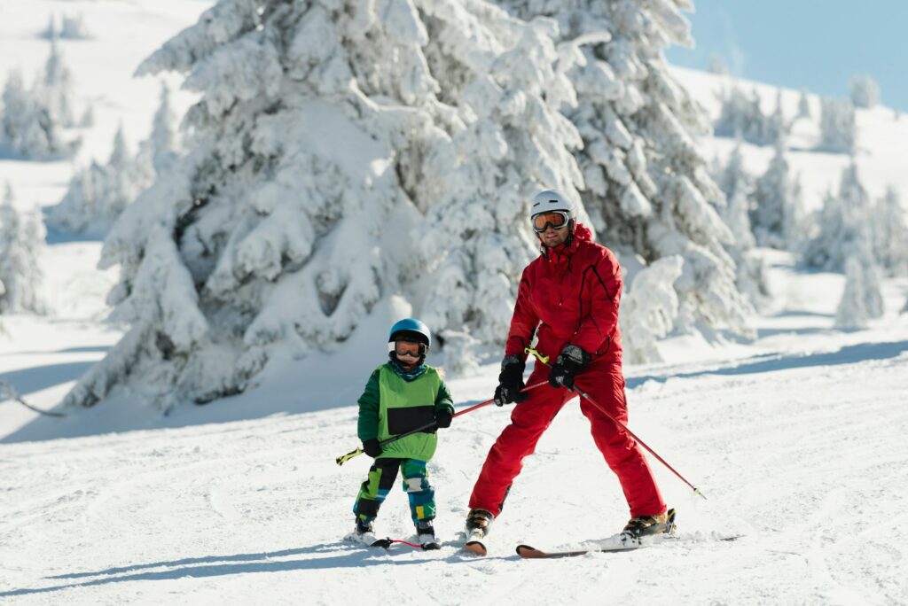 Ski instructor teaching little boy skiing