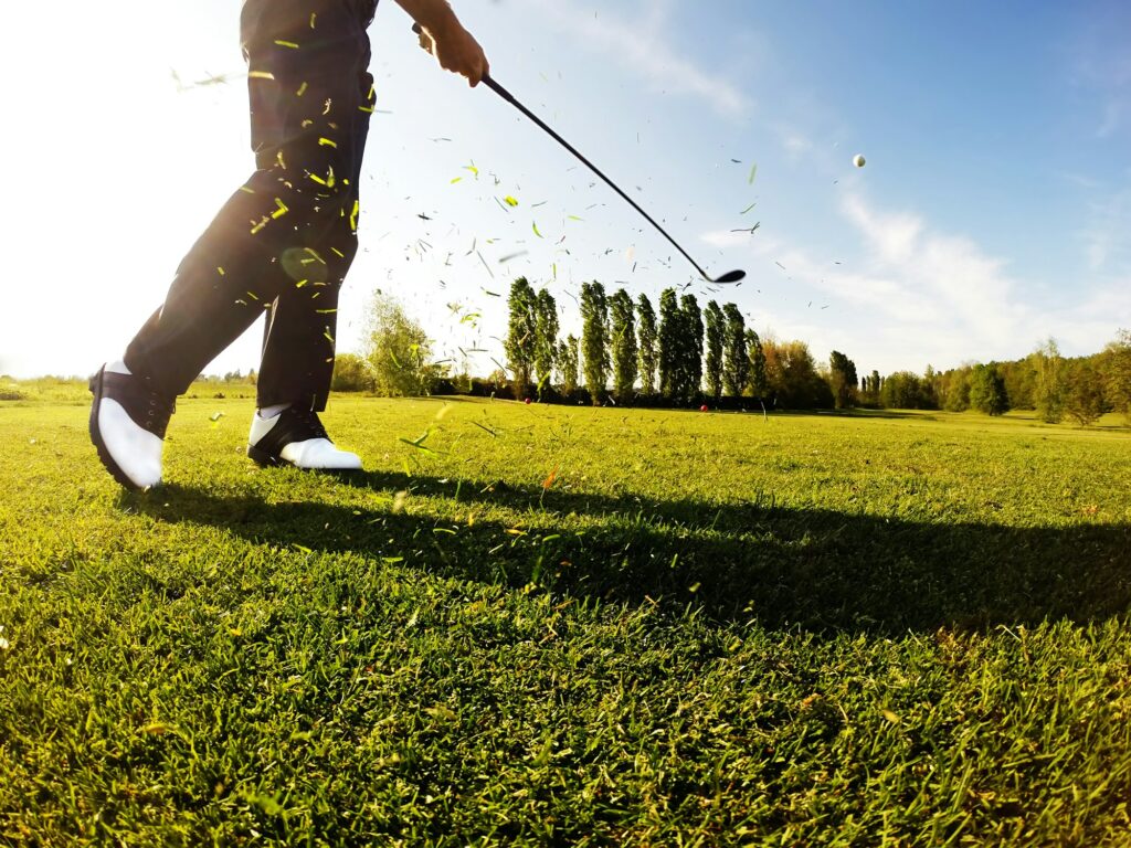 Golfer performs a golf shot from the fairway.