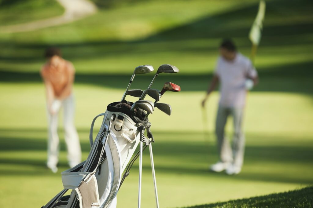 Italy, Kastelruth, Golfers playing golf on golf course