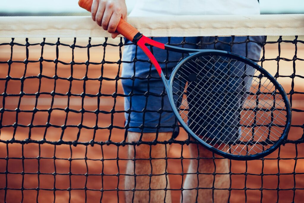 Tennis racket and tennis net on tennis court